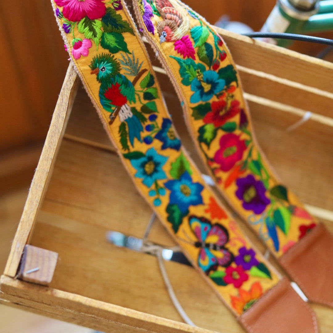 Colorful floral-patterned strap hanging on a wooden stand.