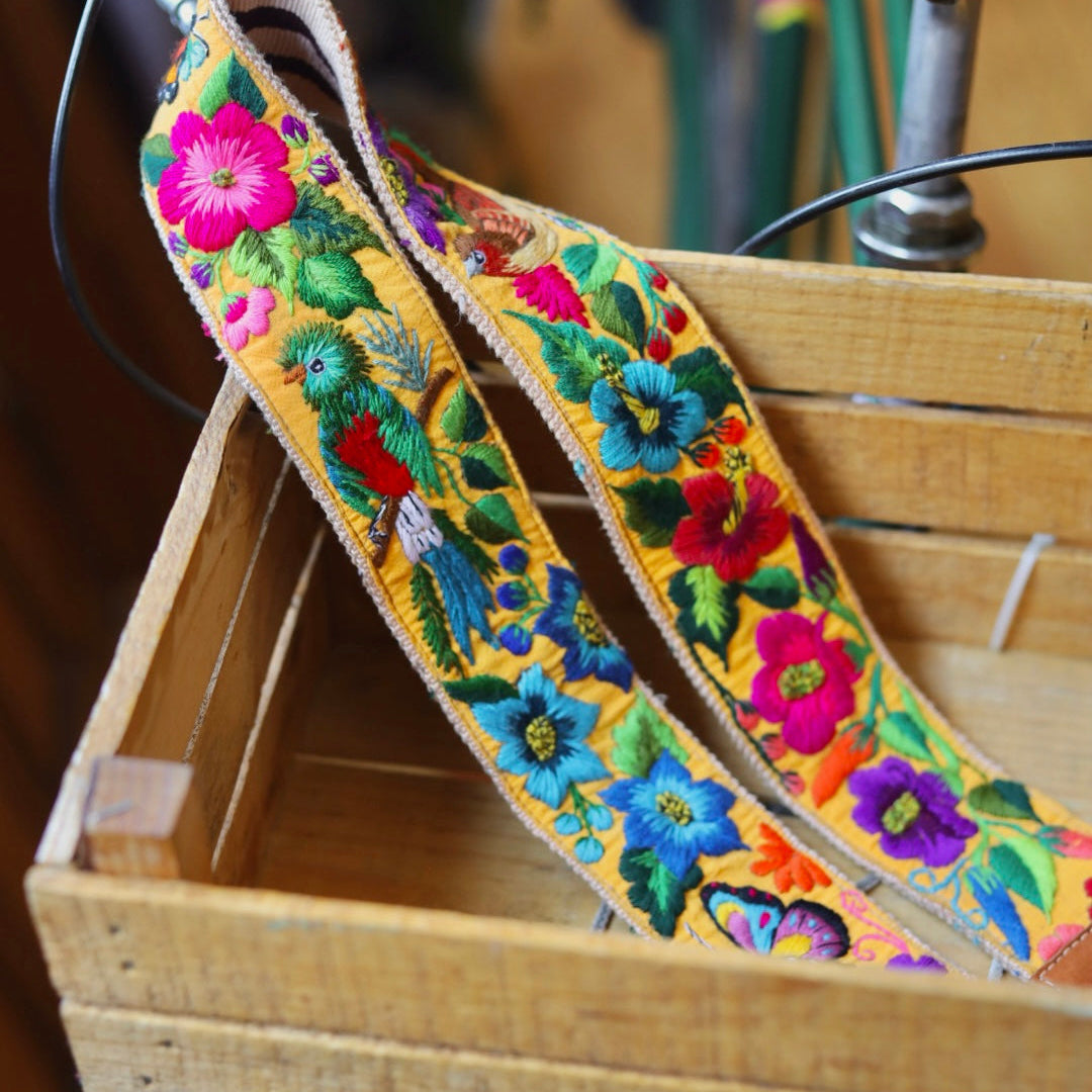 Colorful embroidered strap hanging on a wooden crate with a bicycle in the background
