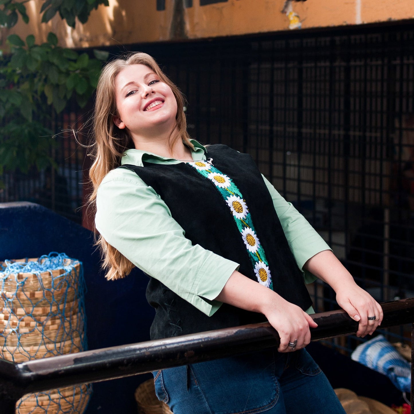 Woman standing next to a black railing with a 'Mercado' sign in the background