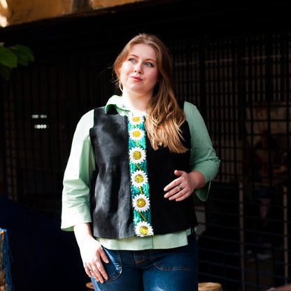 Woman wearing a black vest with floral patterns in an indoor setting