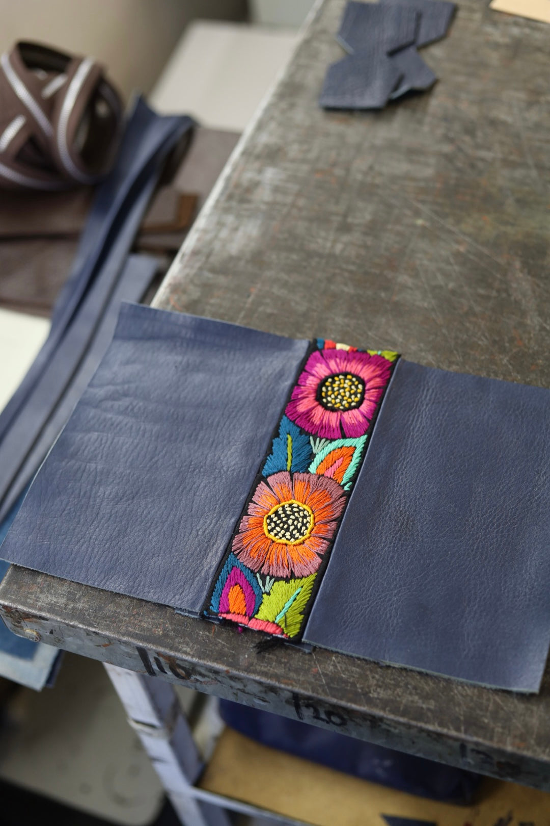 Floral embroidered fabric strip on a dark blue fabric background