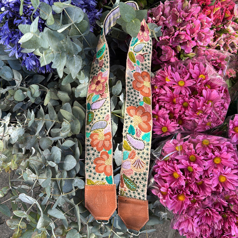 Colorful floral-patterned belt on a bed of flowers and greenery