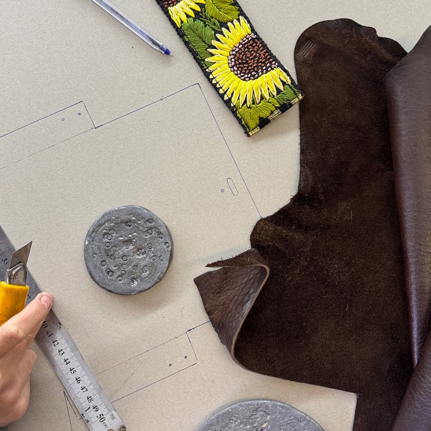 Sunflower-patterned fabric on a cutting mat with tools and materials.