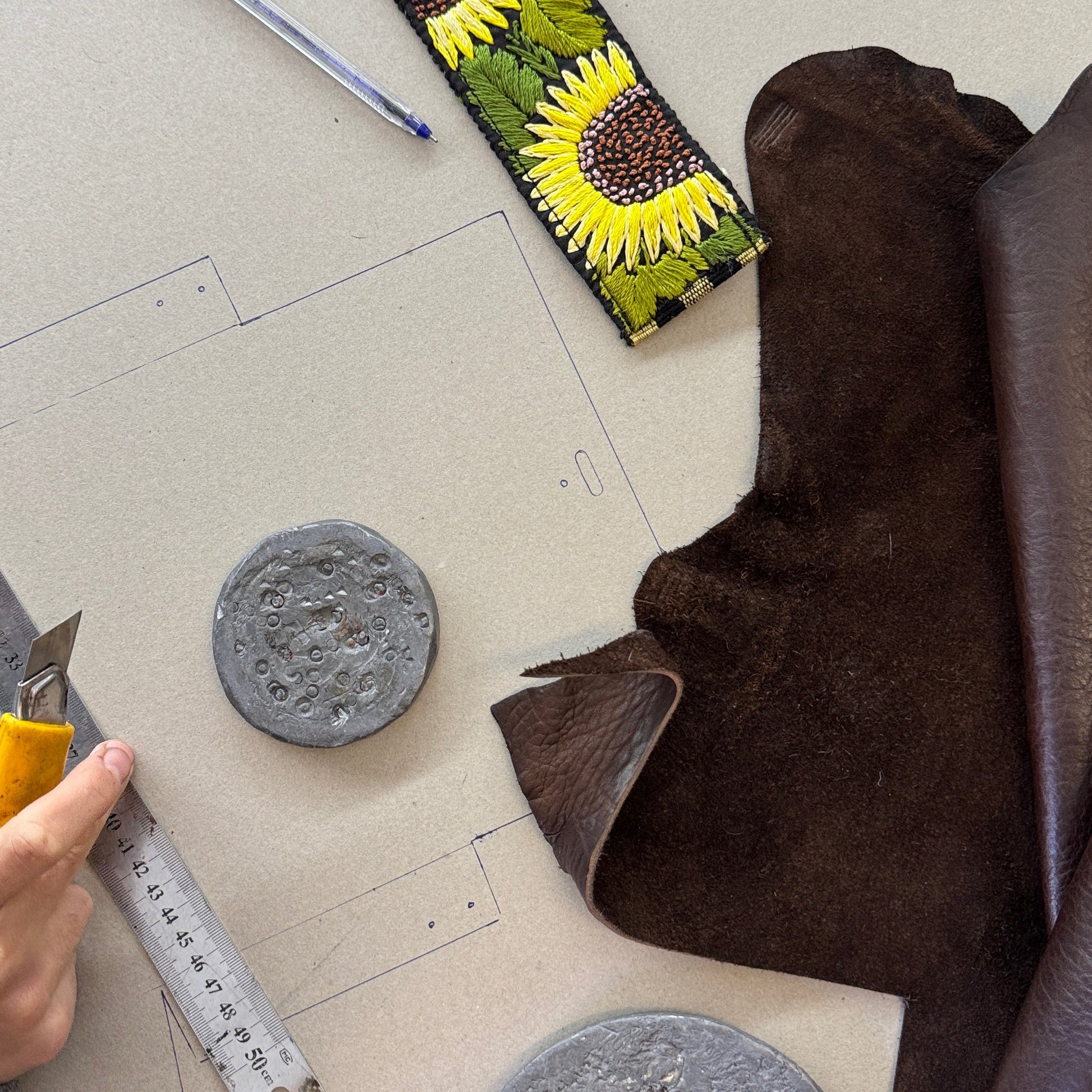 Sunflower-patterned fabric on a cutting mat with tools and materials.