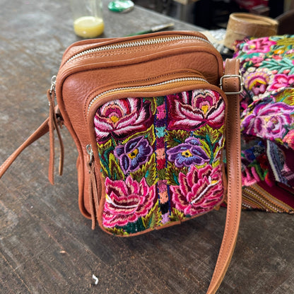 Brown handbag with floral embroidery on a workshop floor with sewing machine in background