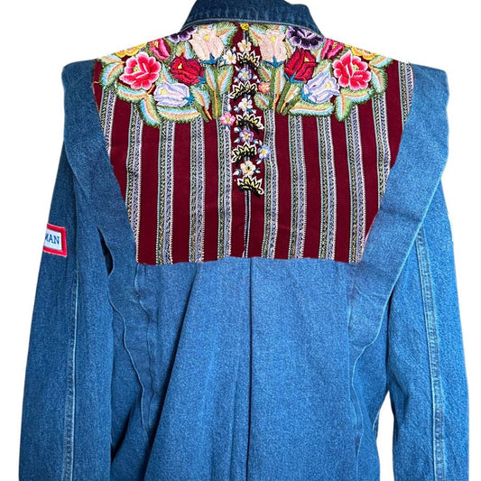 Blue denim jacket with floral embroidery on a white background
