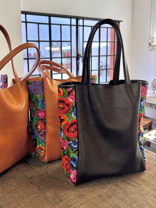 Three tote bags with floral patterns on a wooden floor.