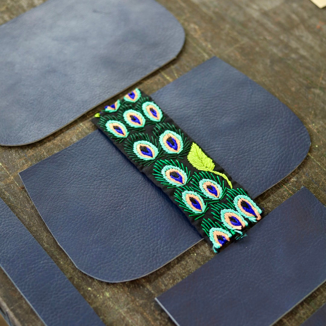 Peacock feather strap on a blue leather background