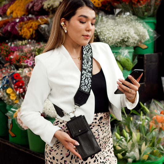 Woman using a phone in front of a flower stand