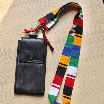 Black phone case with colorful lanyard on a wooden surface
