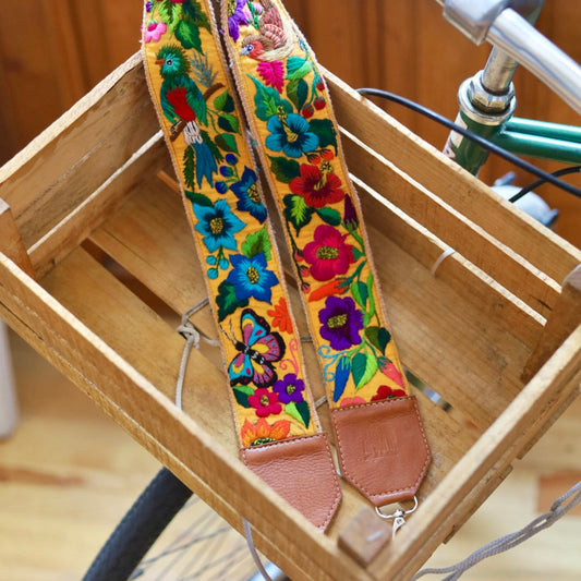 Colorful floral-patterned strap hanging on a bicycle inside a wooden crate.