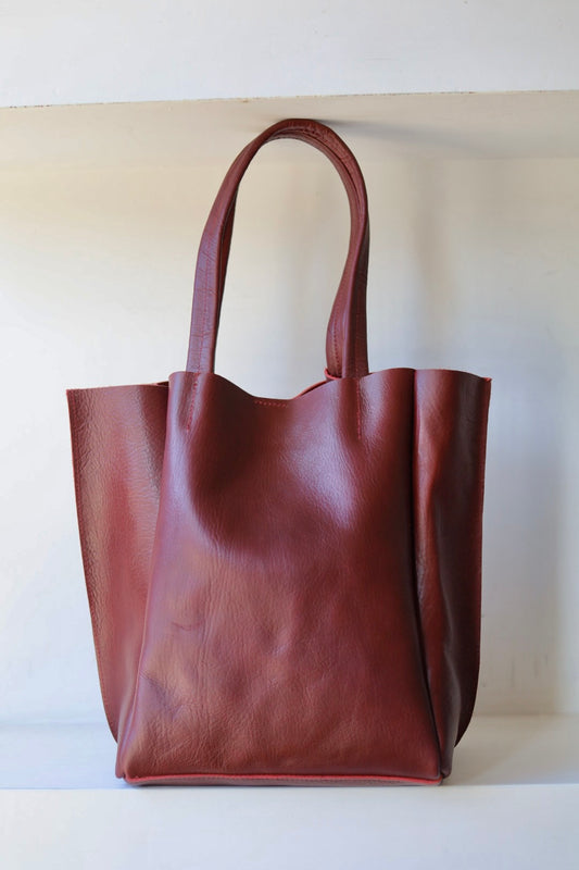 Brown leather tote bag on a white background