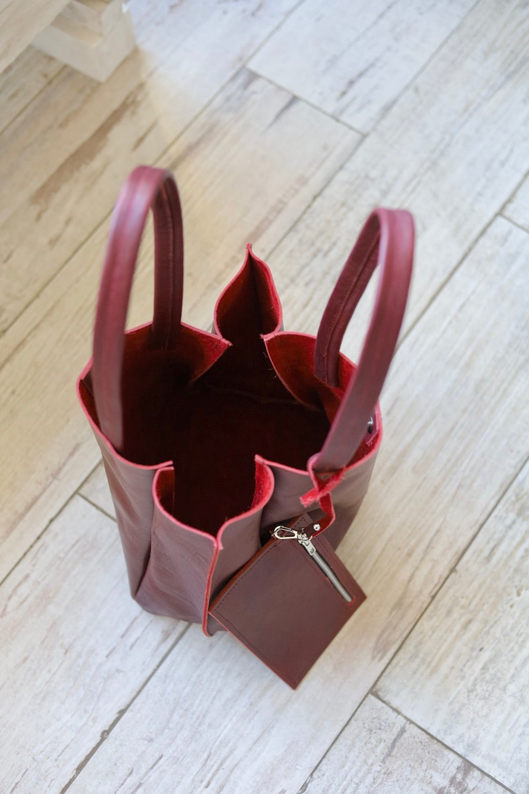 Brown leather handbag on a light wooden floor