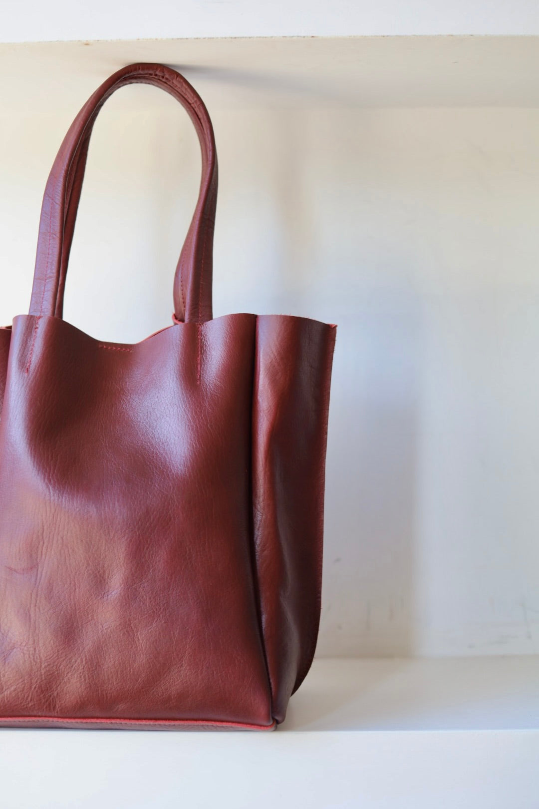Brown leather tote bag on a white background