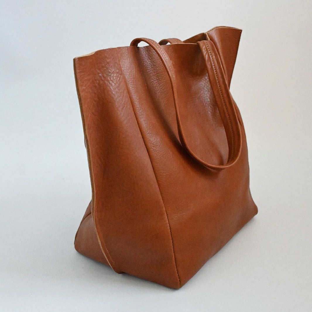 Brown leather tote bag on a white background