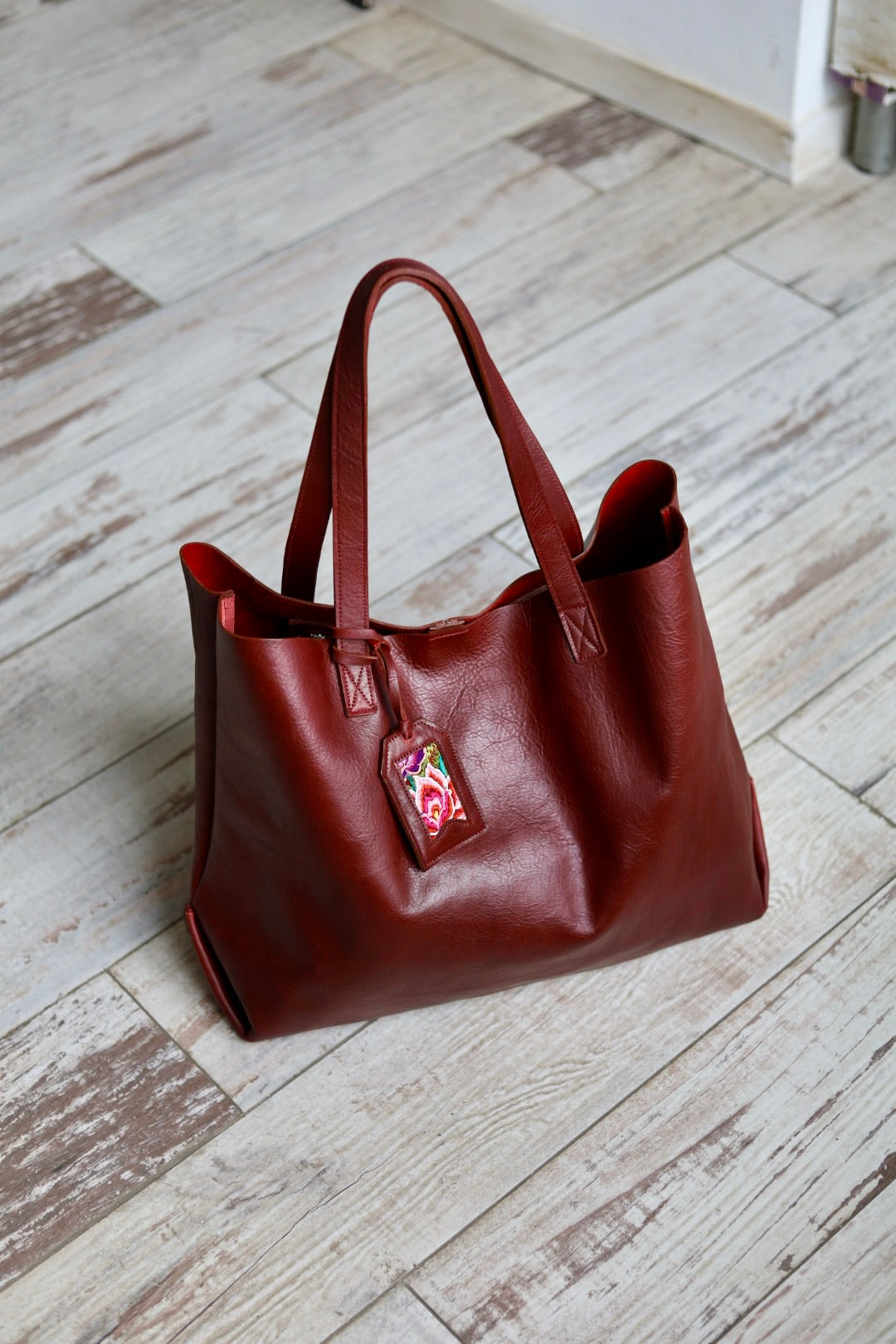 Brown leather handbag on a wooden floor