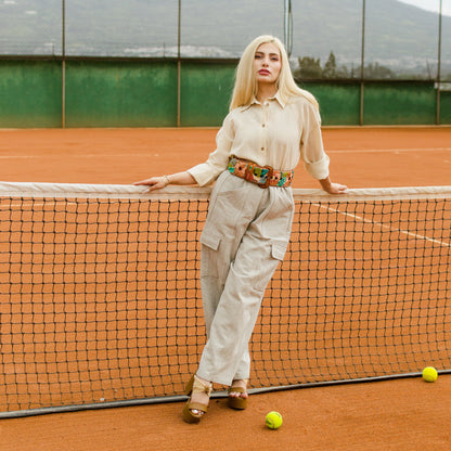 Woman standing on a tennis court with tennis balls around her