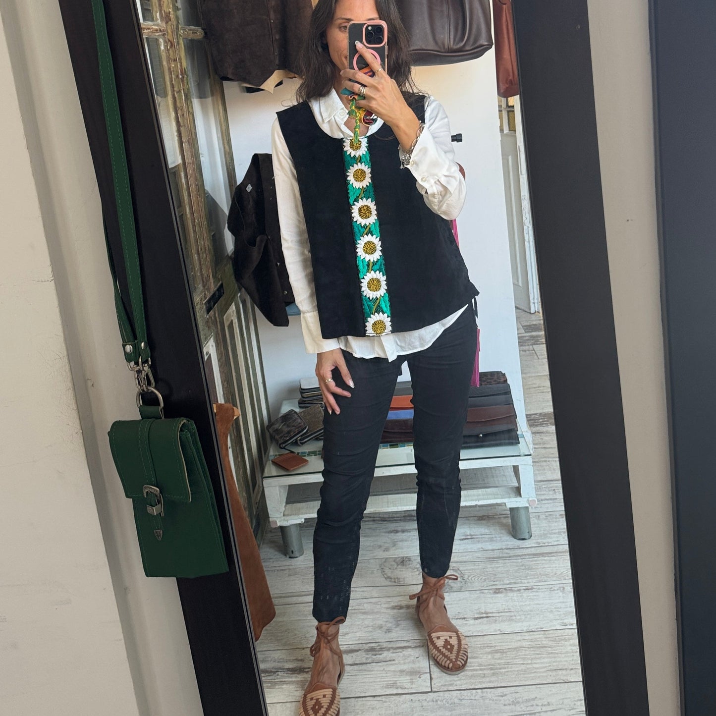 Person wearing a colorful vest in front of a mirror