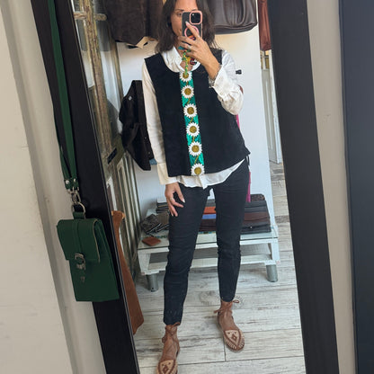 Person wearing a colorful vest in front of a mirror