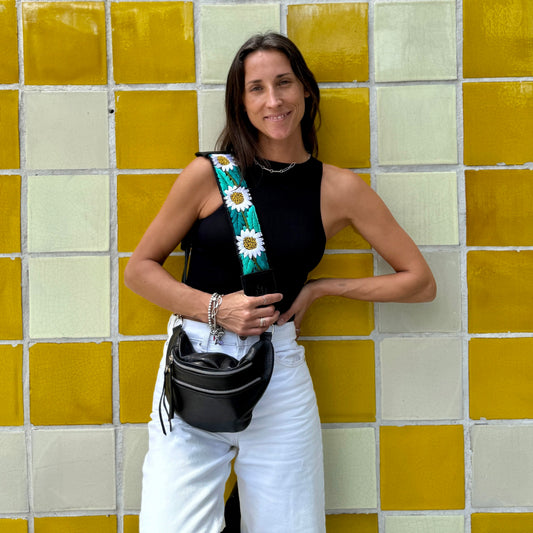 Woman holding a floral bag against a yellow and white tiled wall