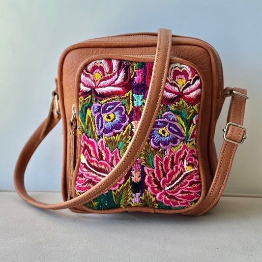 Brown crossbody bag with colorful floral embroidery on a light gray background