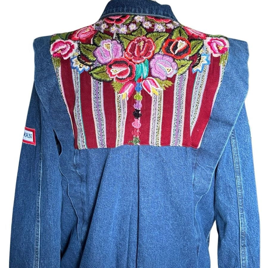 Blue denim jacket with colorful floral embroidery on a white background