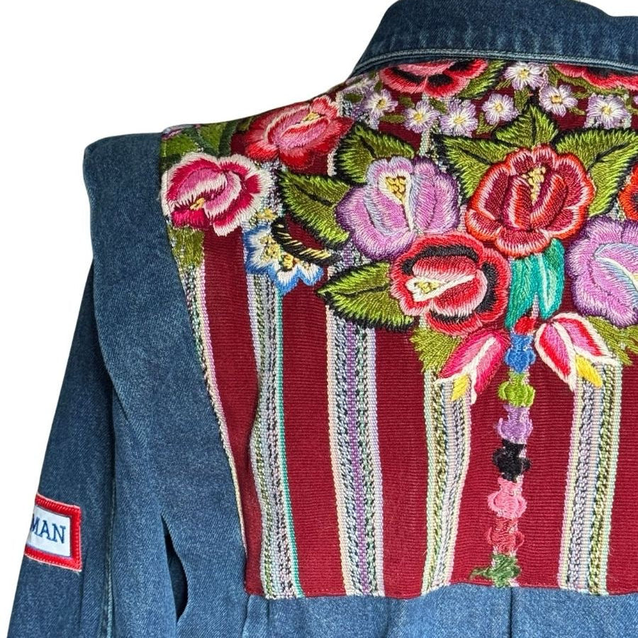 Blue denim jacket with floral embroidery on a mannequin against a white background