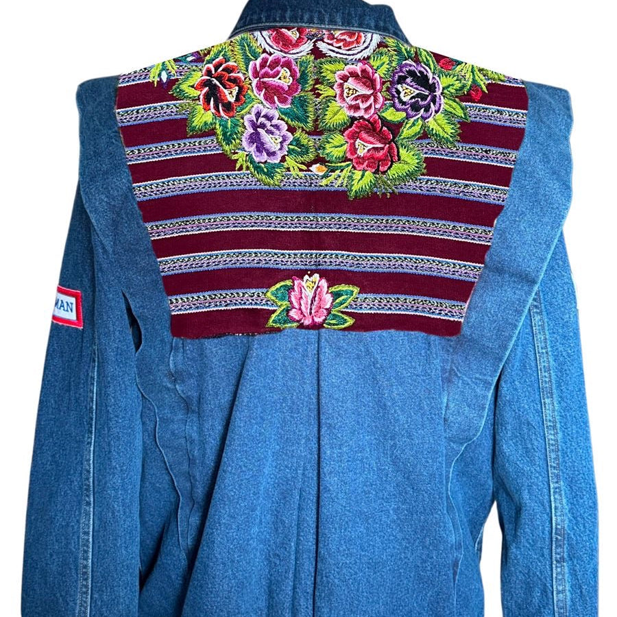Blue denim jacket with floral embroidery on a mannequin against a white background