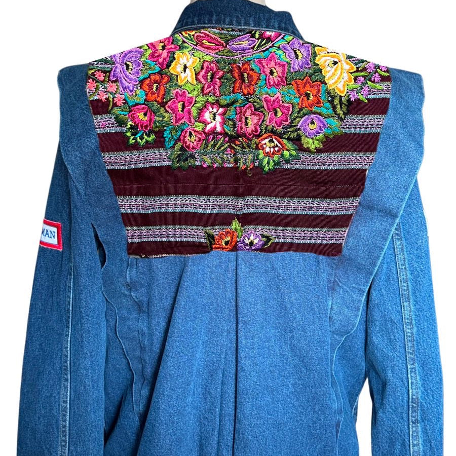 Blue denim jacket with colorful floral embroidery on a white background