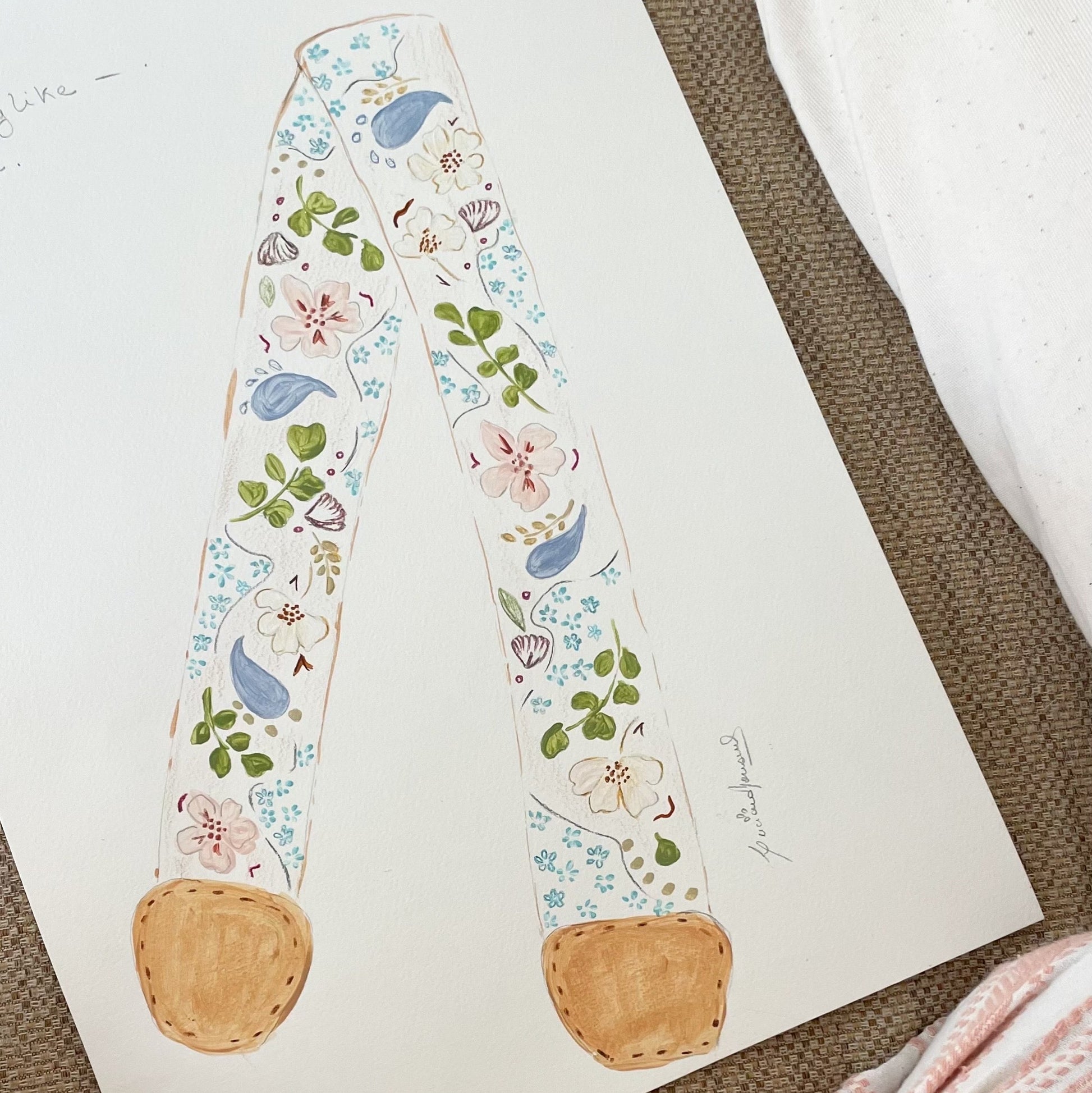 Decorative headband with floral and bird pattern on a white card, placed on a textured surface.